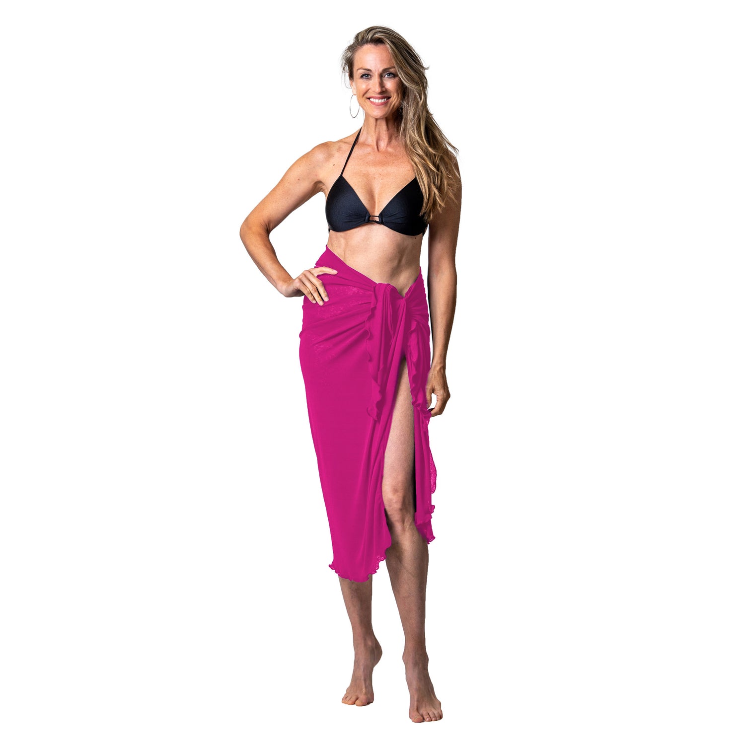 Woman wearing Cover Me Onion Skin Sarong in fuchsia, barefoot, with black bikini top against white background.