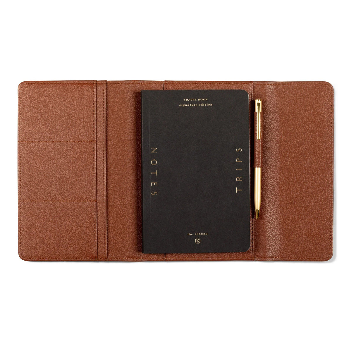 Open brown faux leather Fringe Jet Setter Travel Folio Set containing a black “Notes” and “Trips” journal and gold pen.