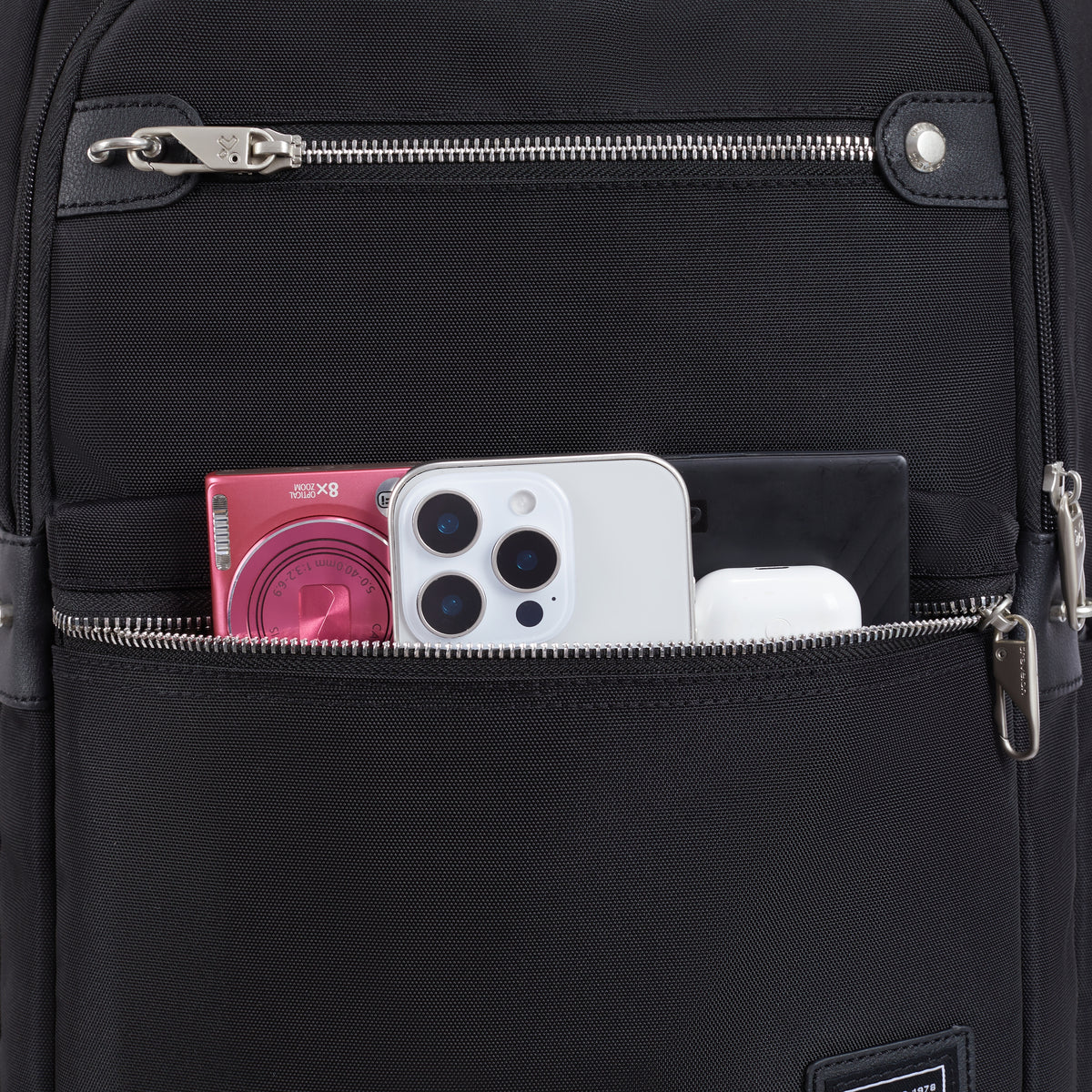 Travelon Anti-theft Heritage Backpack secures phone, camera & earbuds in its RFID blocking front pocket.