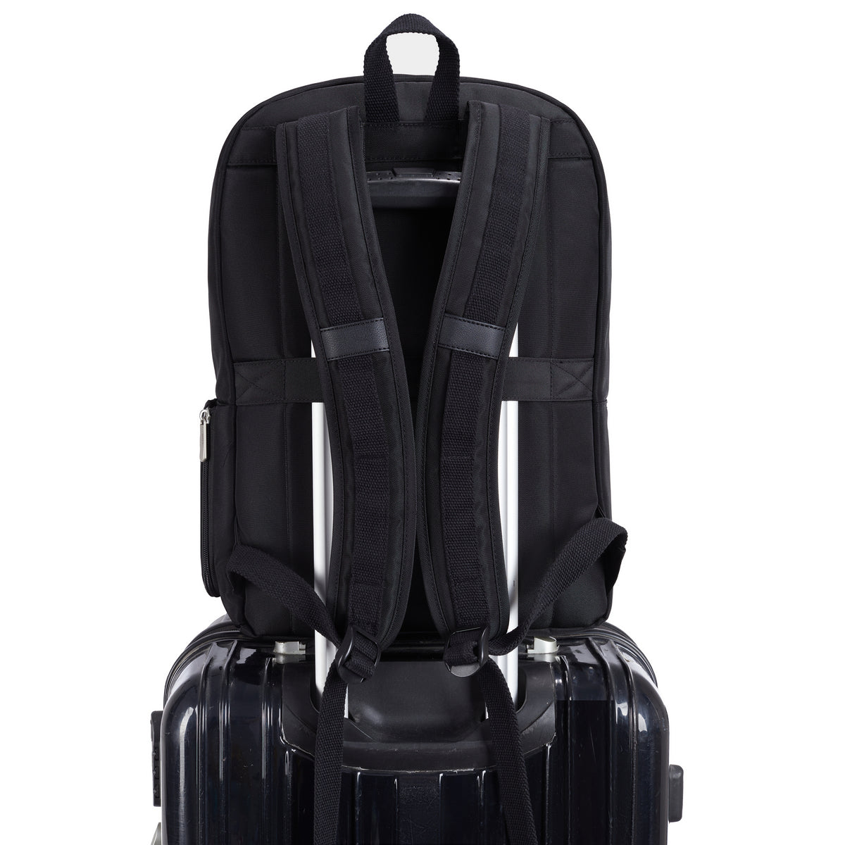 A Travelon Anti-theft Heritage Backpack by Travelon rests atop a hard-shell suitcase with telescoping handle.