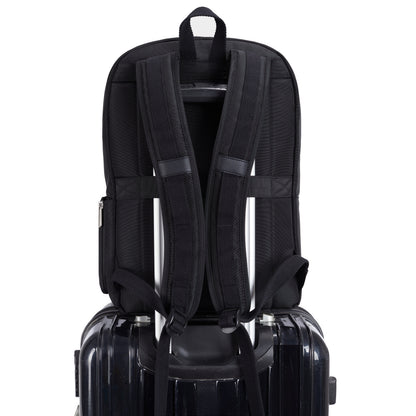 A Travelon Anti-theft Heritage Backpack by Travelon rests atop a hard-shell suitcase with telescoping handle.