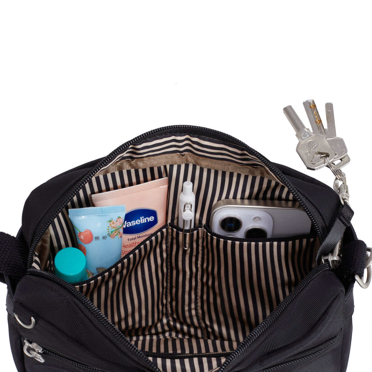 Open Travelon Anti-theft Heritage Crossbody fits keys, phone, sanitizer & more; striped lining inside.