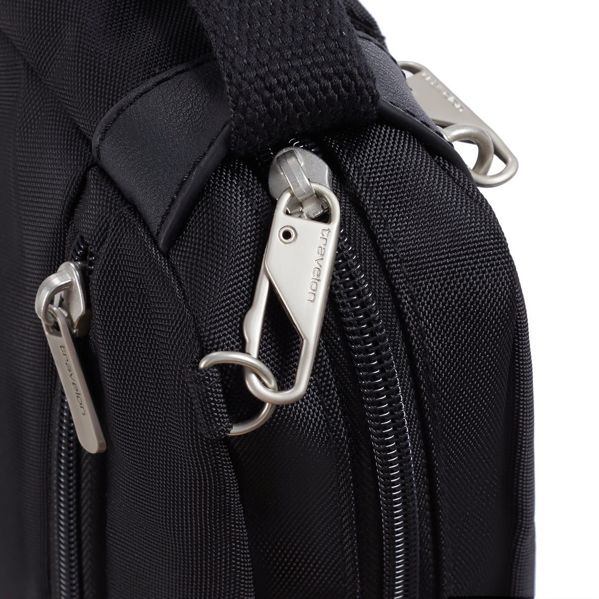Close-up of Travelon Anti-theft Heritage Crossbody zipper pulls, locking clip & side security features.