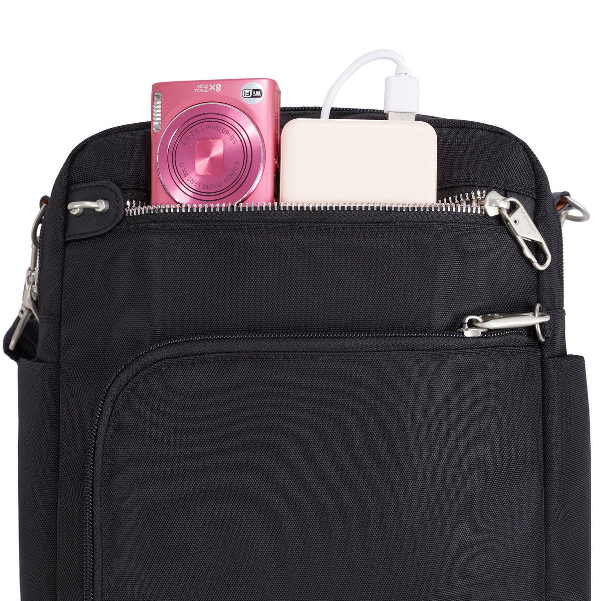 Travelon Anti-theft Heritage Tour Bag in black with a pink camera and white power bank in the top pocket.