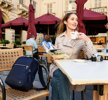 Women enjoying coffee with a travel backpack beside