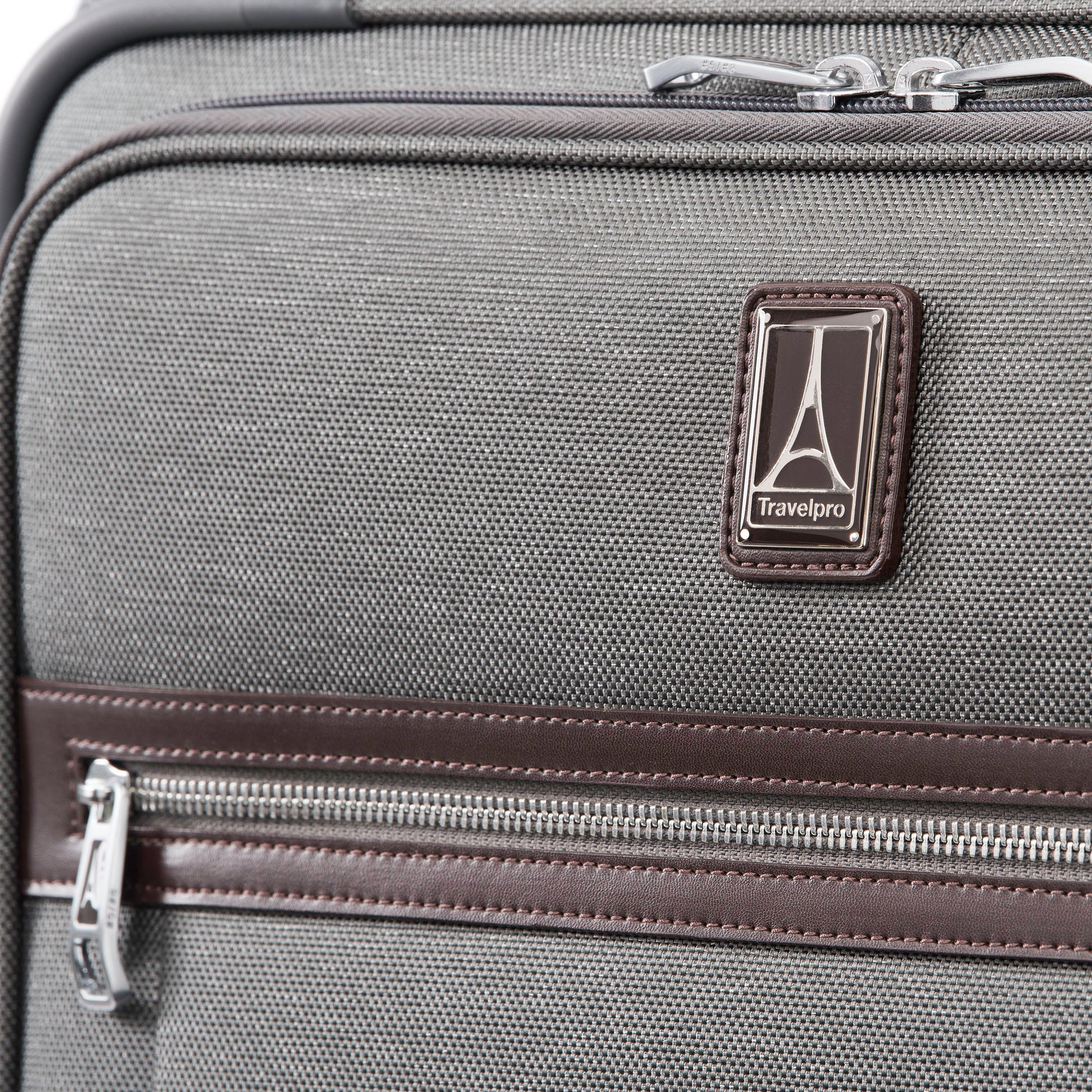 Close up of leather trim around front zipper and Travelpro logo on the vintage grey Travelpro® Platinum® Elite 29" Expandable Spinner