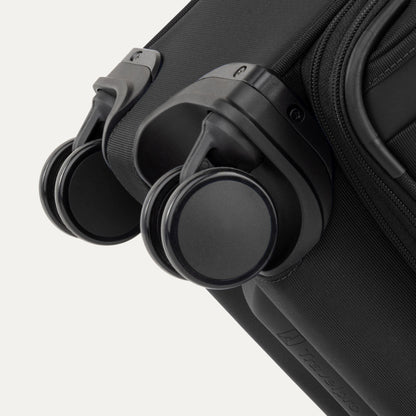 Close-up of two black spinner wheels on the Travelpro VersaPack+ Carry-on Expandable Spinner suitcase.
