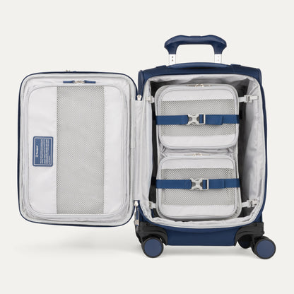 Travelpro® VersaPack®+ navy carry-on spinner with packing cube organizer, straps, and mesh pockets inside.
