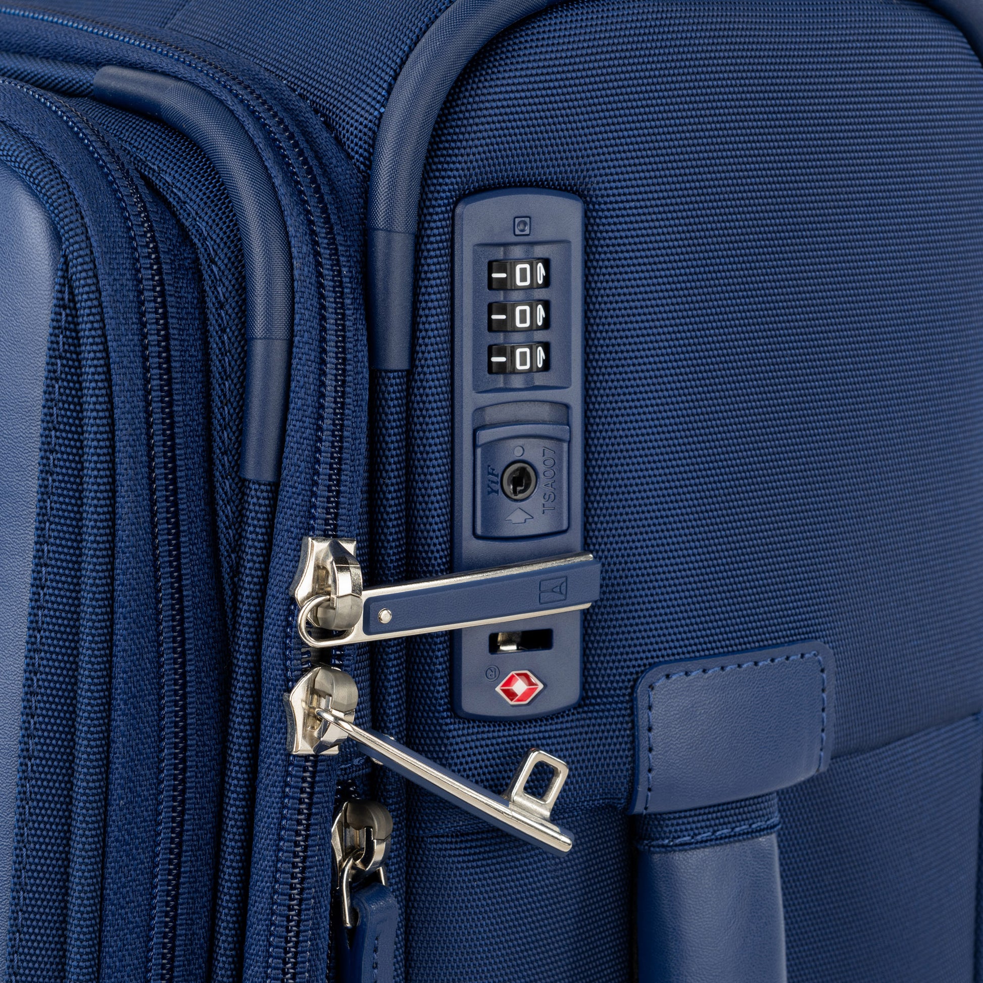 Close-up of Travelpro VersaPack+ Compact Carry-on Spinner in blue with TSA lock securing two zipper pulls.