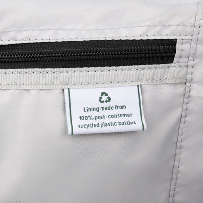 Close-up of Travelpro VersaPack+ label: water-resistant lining made from recycled plastic bottles.