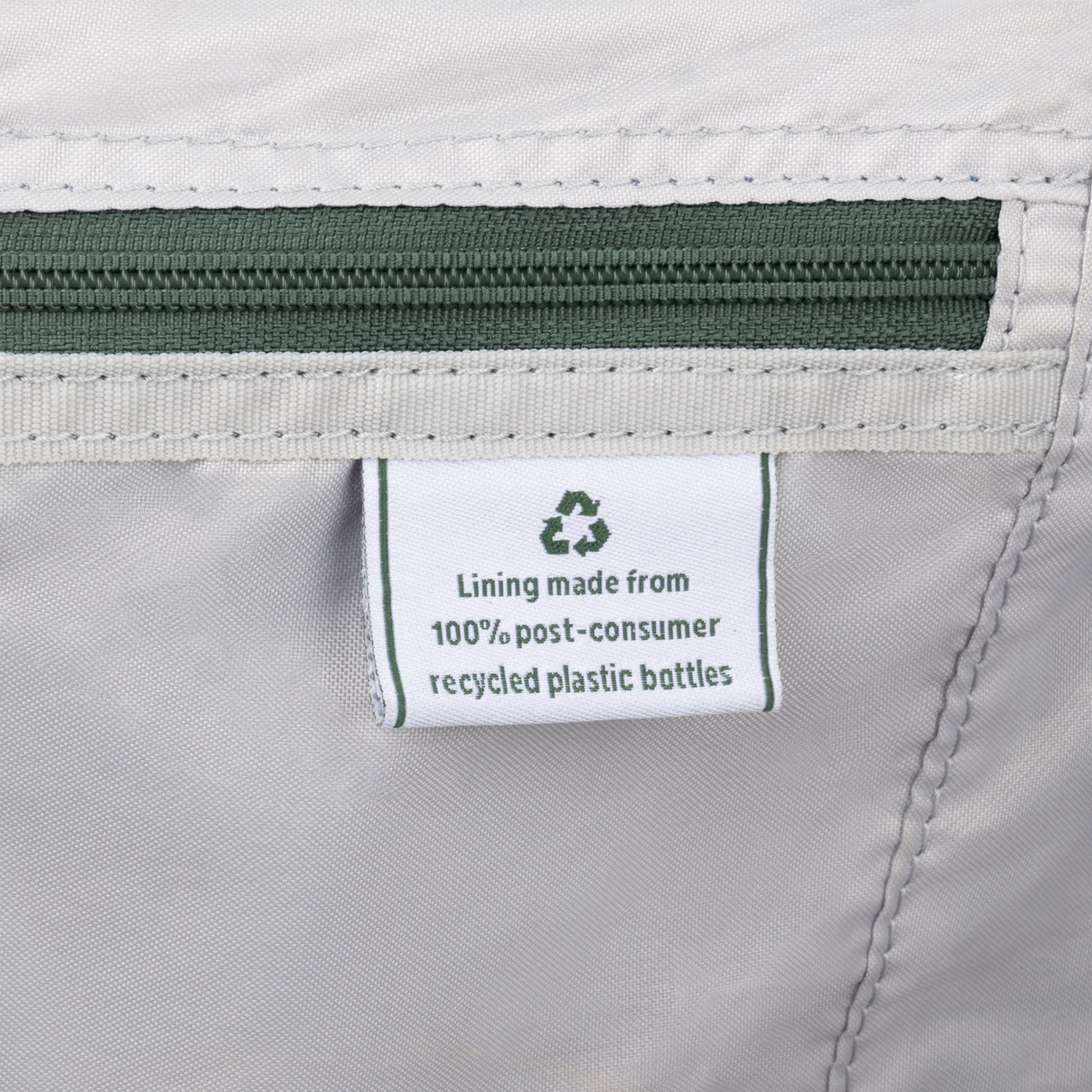 Close-up of a tag on the Travelpro® VersaPack®+ showing its water-resistant lining is 100% recycled plastic bottles.