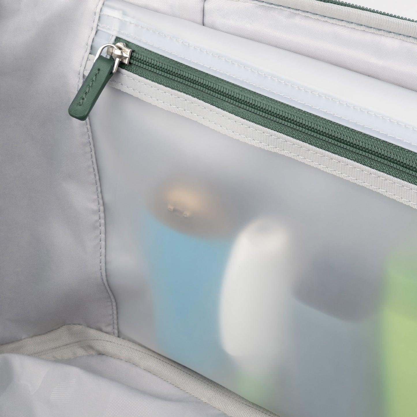 Close-up of the Travelpro® VersaPack®+ Spinner's mesh toiletry pocket with water-resistant lining and travel items.