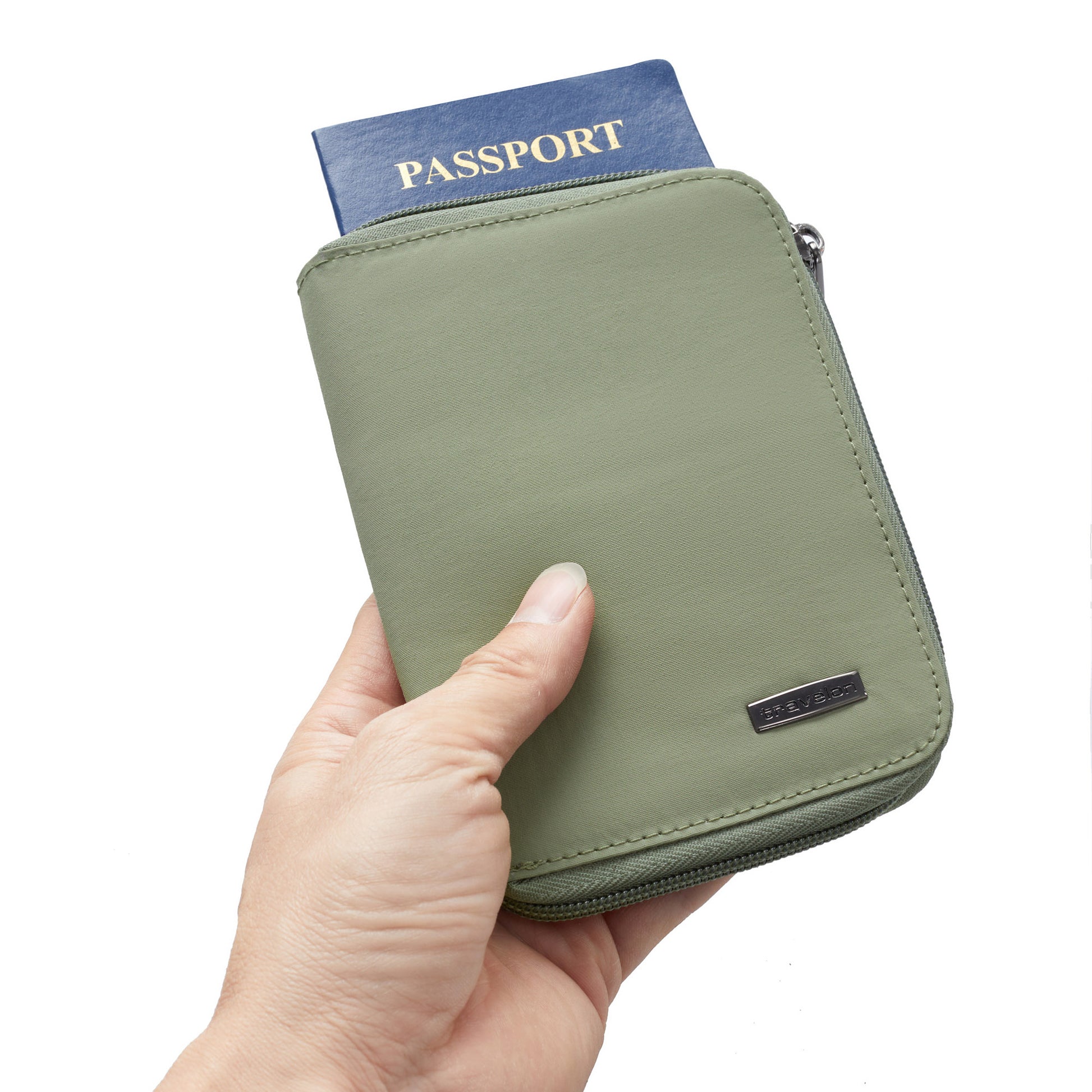 A hand holds the Travelon RFID Blocking Family Passport Wallet with a blue passport partly visible inside.