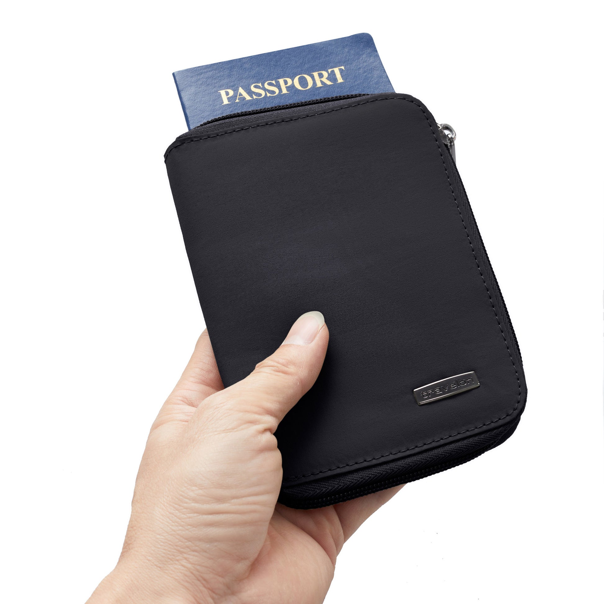 A hand holds the Travelon RFID Blocking Zip Passport Wallet (ONLINE ONLY) with a passport inside against a white background.