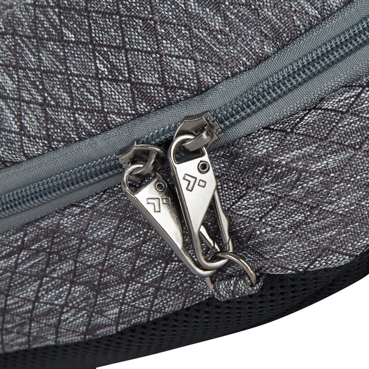 Close-up of a grey Travelon Greenlander 9L Backpack with two silver zippers partially open.