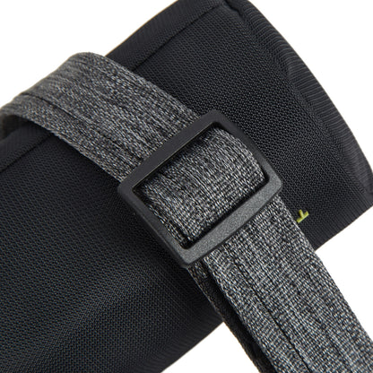 Close-up of Travelon's gray strap with anti-theft black buckle on a textured surface.