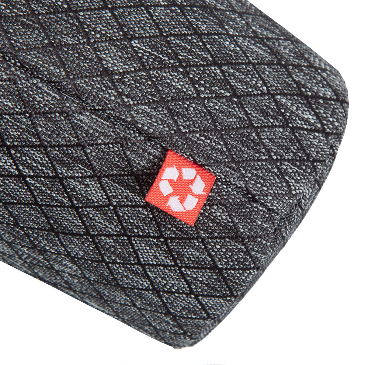 Close-up of the Travelon Anti-Theft Greenlander bag's black textured fabric, red tag, and recycling symbol.