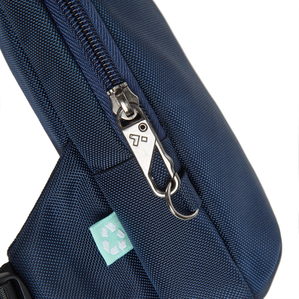 Close-up of Travelon Anti-Theft Sling, blue with metal zipper and recycled symbol tag.