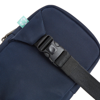 Close-up of a Travelon Anti-Theft Greenlander sling's black strap and buckle on eco-friendly blue fabric.