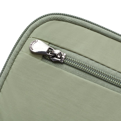 Close-up of the Travelon RFID Blocking Zip Passport Wallet in light green, featuring a zipper and metal pull tab.