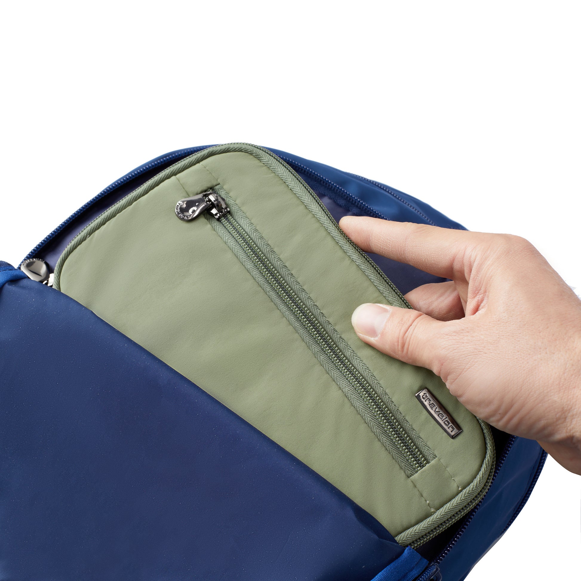 A hand puts a Travelon RFID Blocking Zip Passport Wallet into a blue bag against a white background.