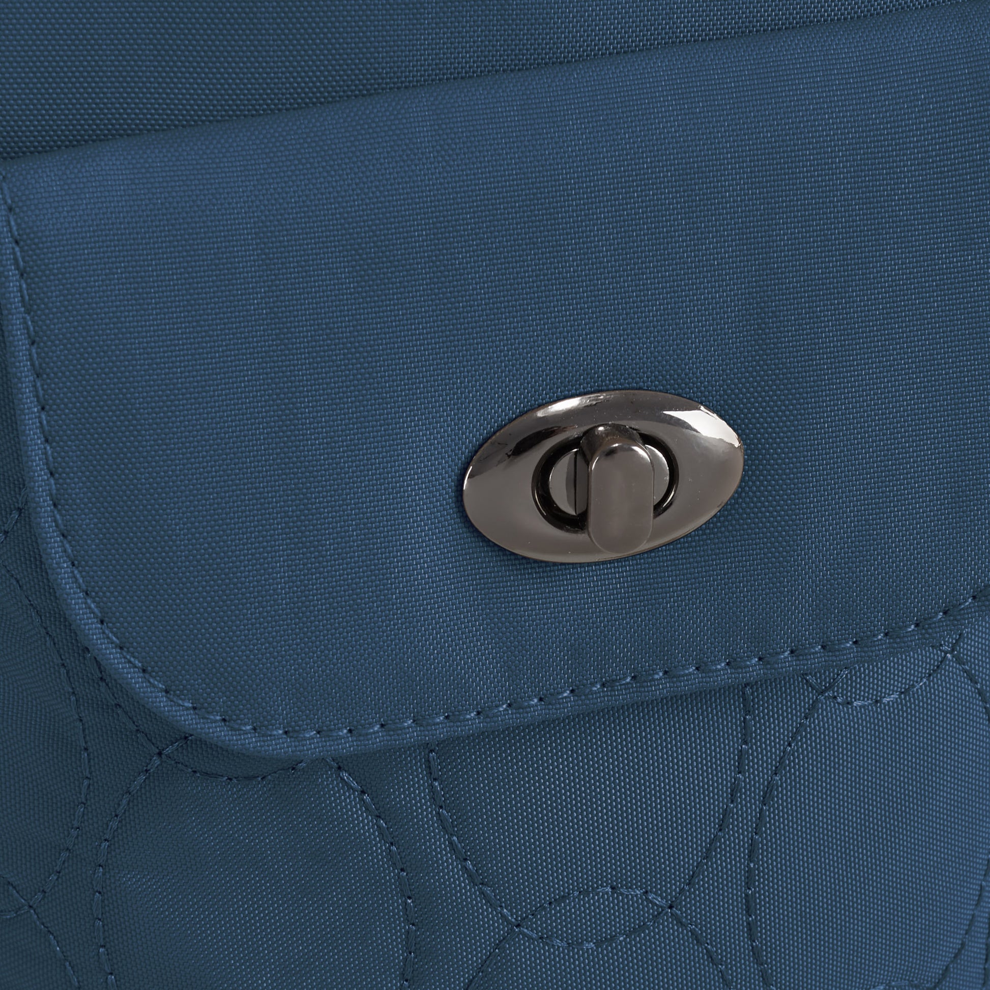 Close-up of the Travelon Runways Anti-theft Slim Asymmetric Crossbody in blue with a silver turn-lock clasp.