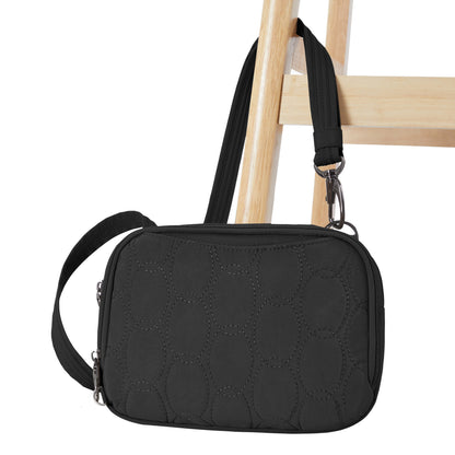 The Travelon Runways Anti-theft Double Compartment Crossbody in black quilted style hangs on a wooden chair.
