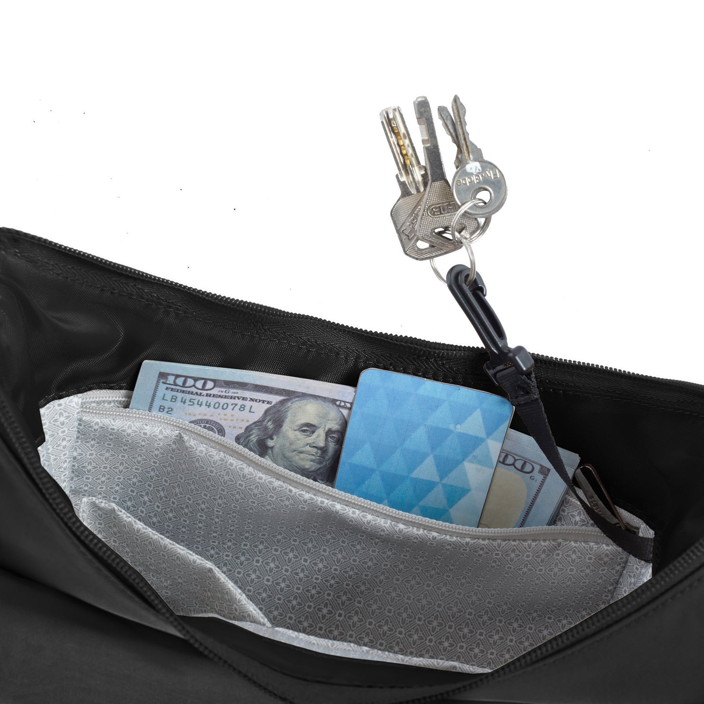 A close-up of the Travelon Runways Anti-theft Medium Crossbody bag pocket holding keys, cash, and a blue card.