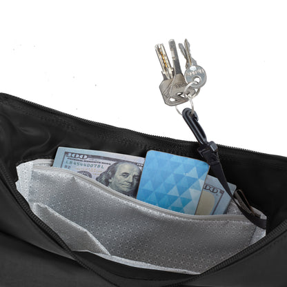 A close-up of the Travelon Runways Anti-theft Medium Crossbody bag pocket holding keys, cash, and a blue card.