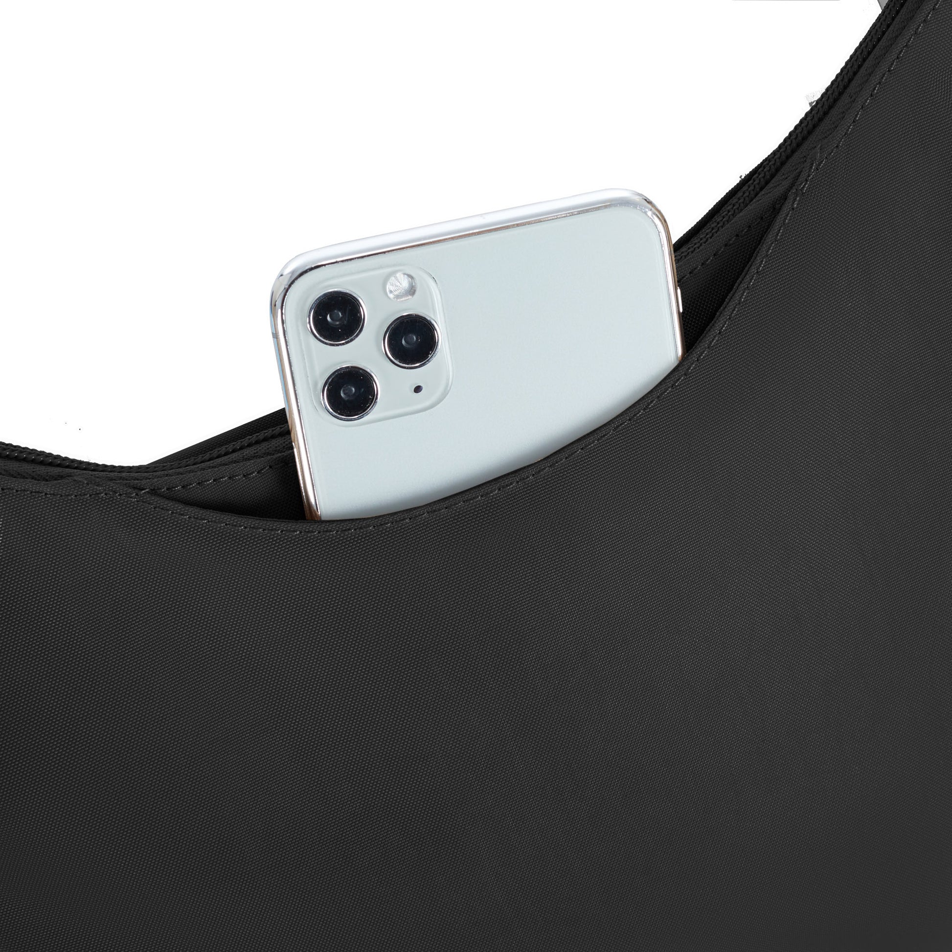 A smartphone with three rear cameras peeks from a Travelon Runways Anti-theft Crossbody against white.