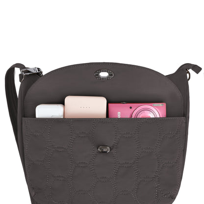 Open Travelon Runways Anti-theft Crossbody shows a white case, pink device & power bank in the front pocket.