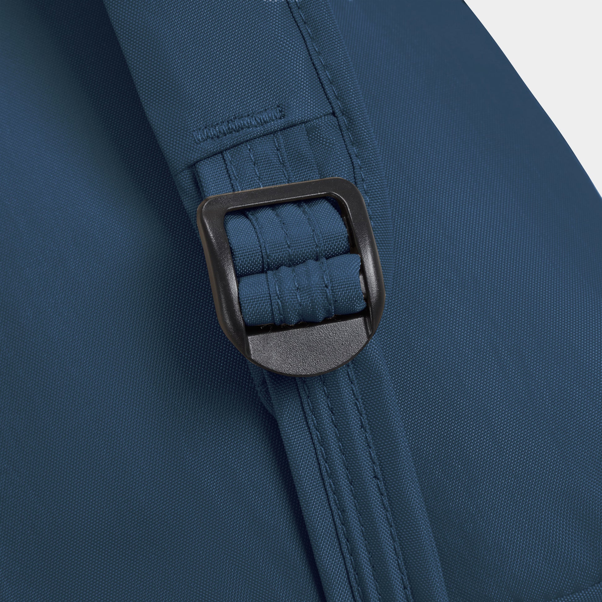 Close-up of the Travelon Runways Anti-theft Compact Backpack in blue with a black plastic buckle on the strap.