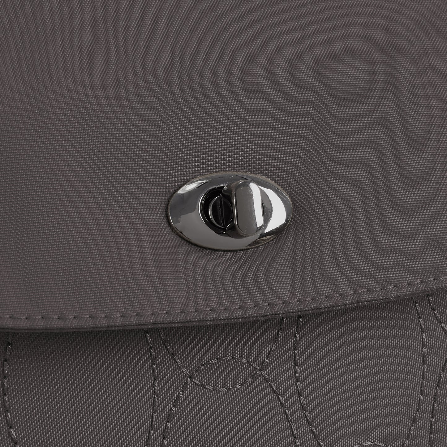 Close-up of the gray Travelon Runways Anti-theft Compact Backpack flap with a silver twist-lock clasp.