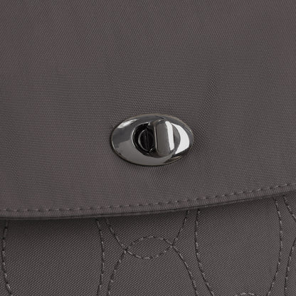 Close-up of the gray Travelon Runways Anti-theft Compact Backpack flap with a silver twist-lock clasp.