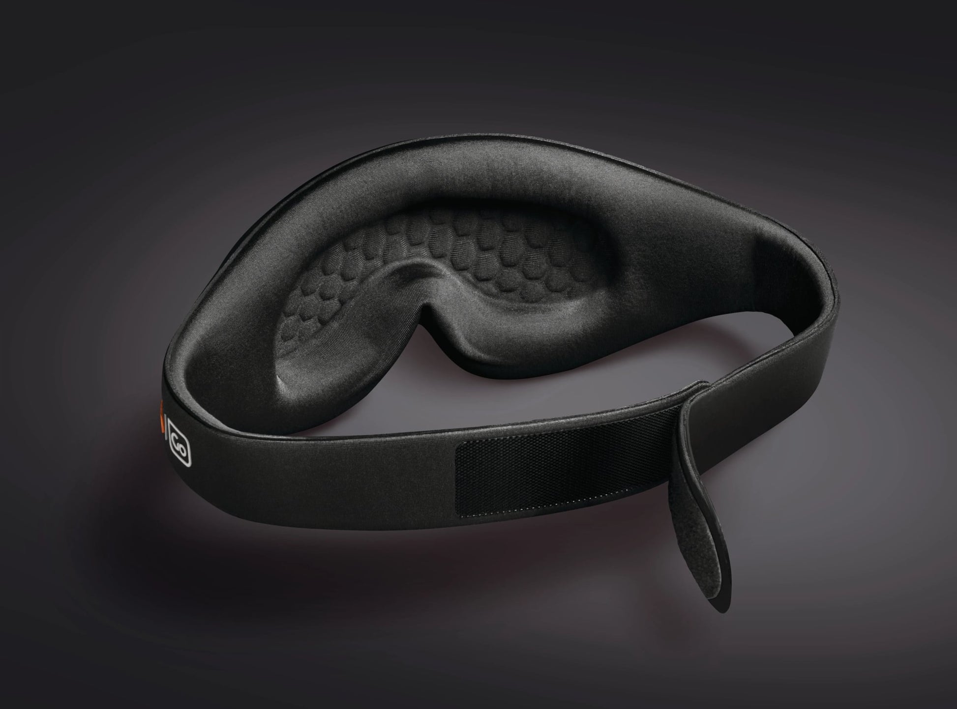 Go Travel The Ultimate Eye Mask by Go Travel with adjustable Velcro strap shown on a dark background.