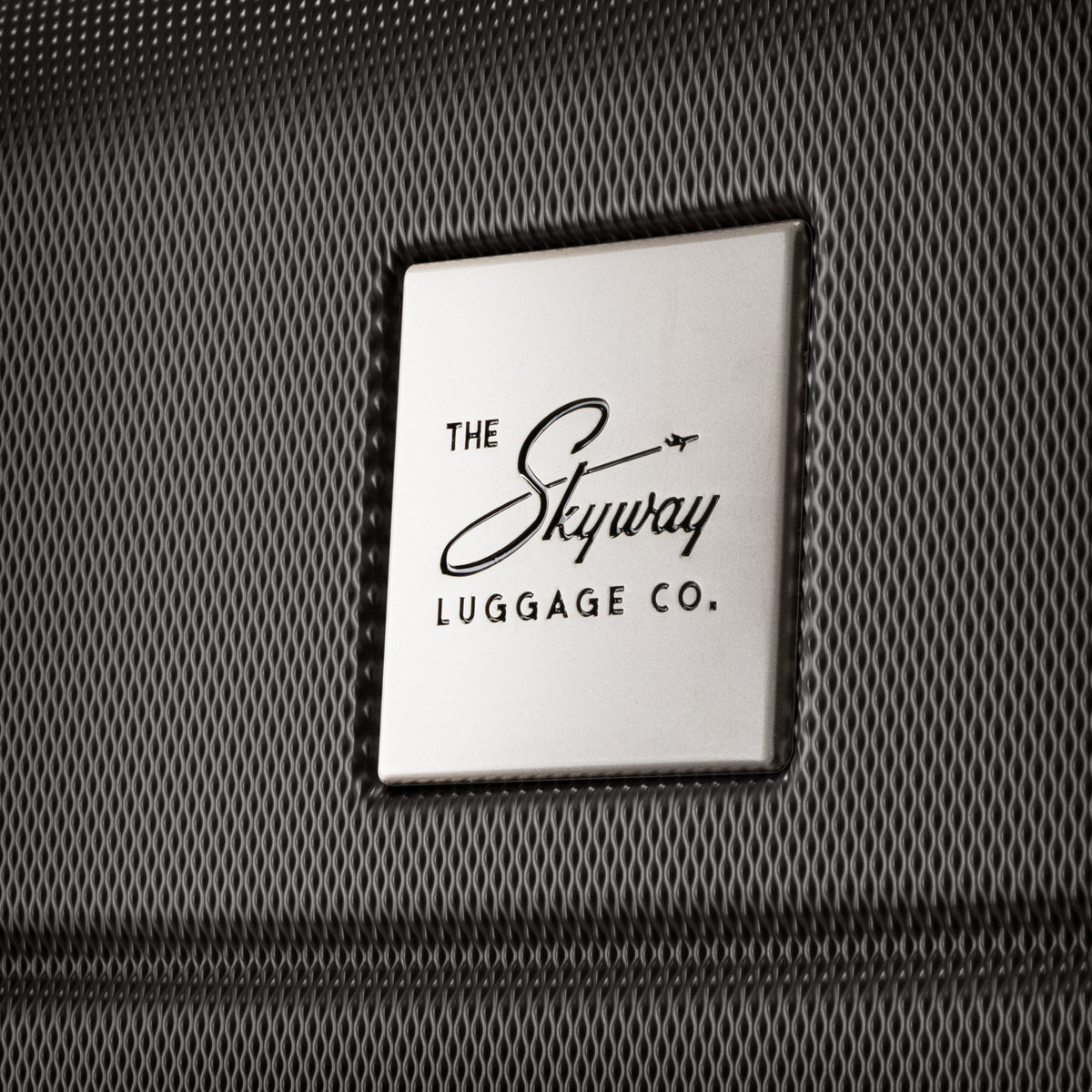 Skyway Epic 2.0 Hardside Carry-on Spinner logo plaque shown on textured black exterior. Online only.