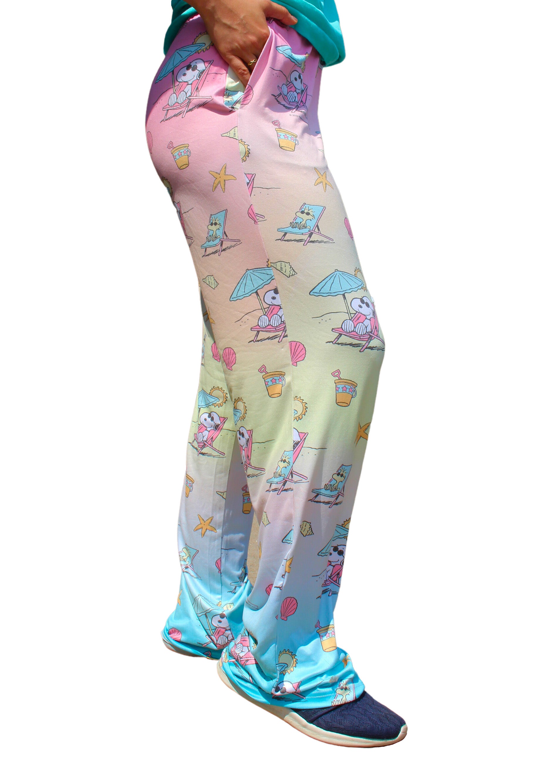 Person wearing Brief Insanity Lounge Pants - Peanuts Snoopy Beach, hands in pockets, and blue shoes.