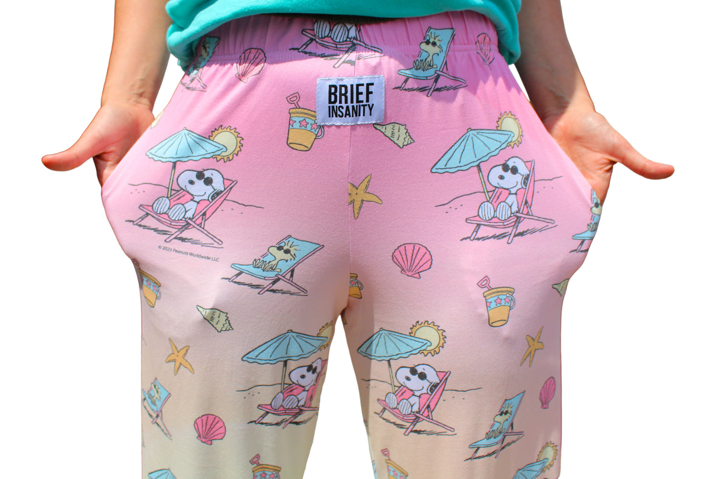 Person wearing Brief Insanity Peanuts Snoopy Beach lounge pants, hands in pockets.
