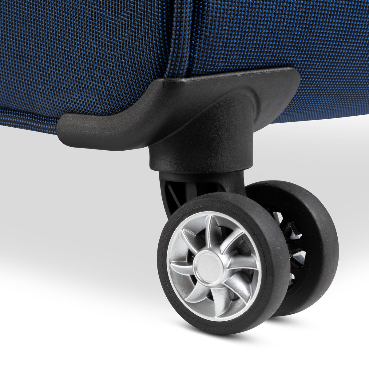 Close-up of a blue spinner wheel assembly on a Skyway Flair 2.0 3-Piece Luggage Set.