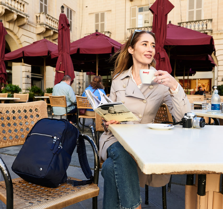 Women enjoying coffee with a travel backpack beside