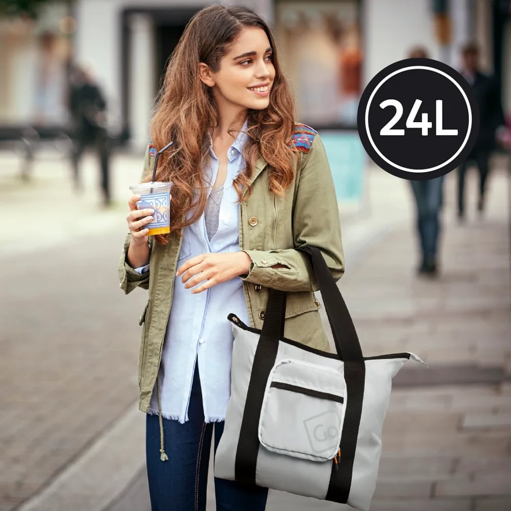 Woman carries the Go Travel Lightweight Foldaway Tote Bag while walking outdoors on a city street.