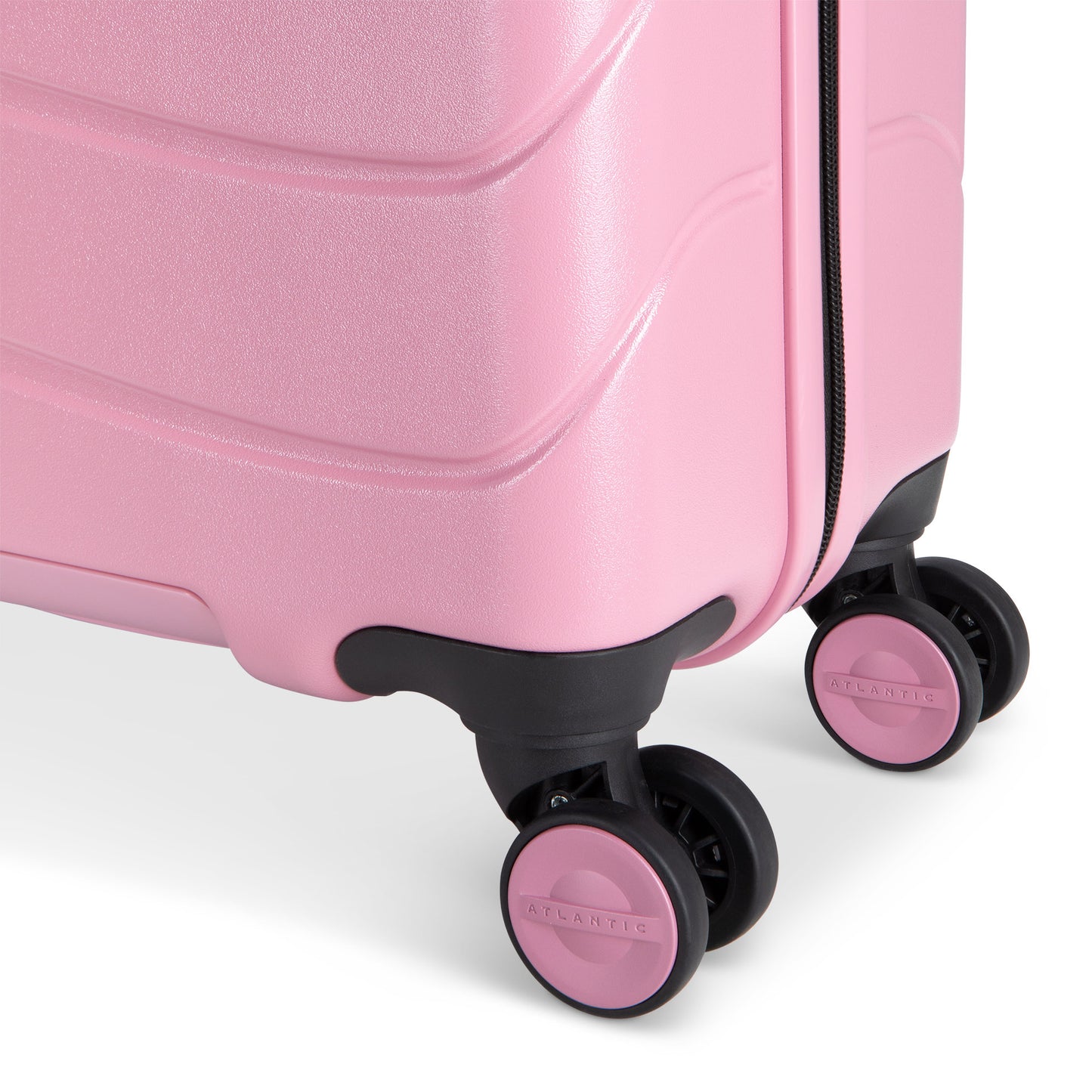 Close up of black and pink spinner wheels on blush pink Atlantic Transmarine 19" Hardside Spinner Carry-on