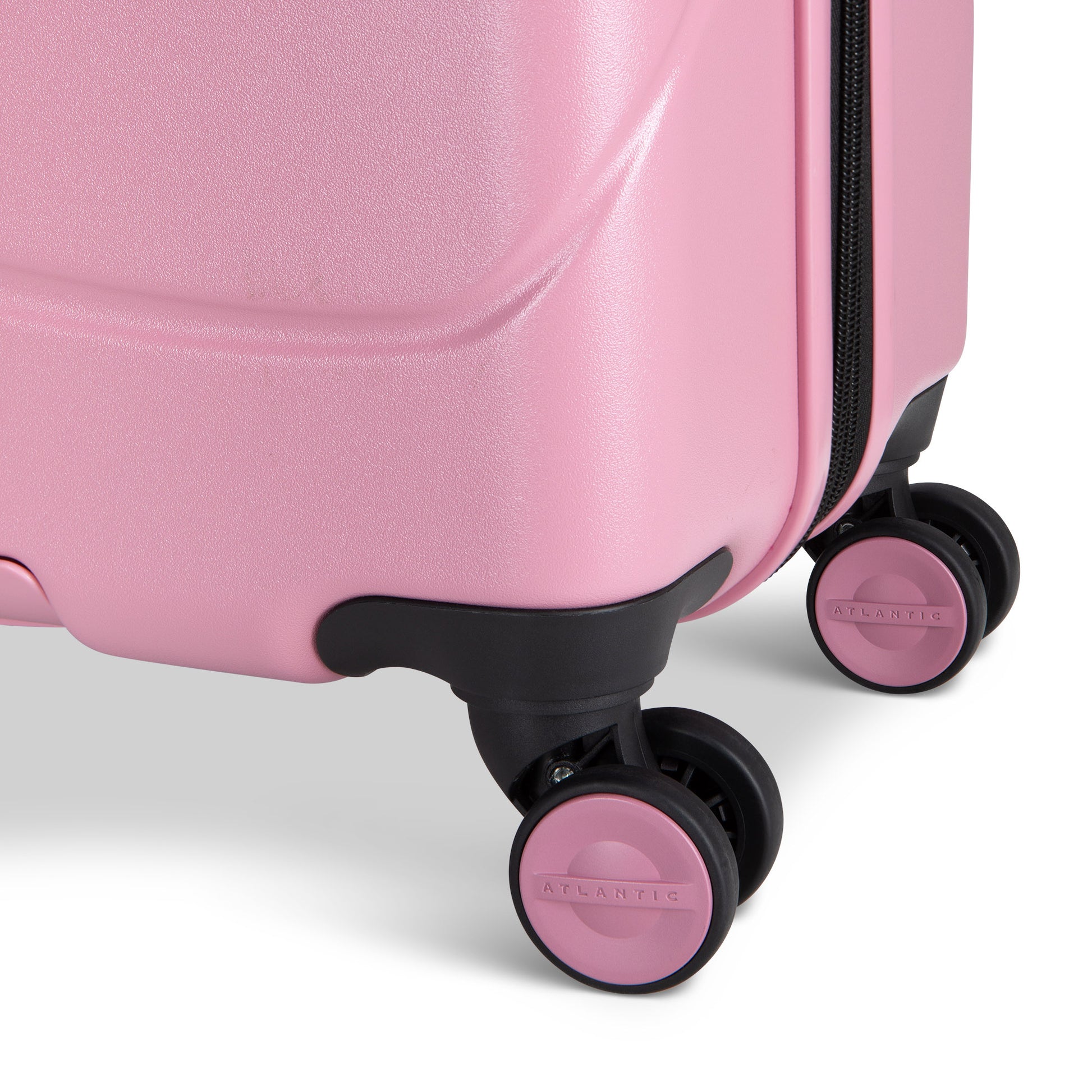 Close up of black and pink spinner wheels on blush Atlantic Transmarine 24" Expandable Spinner