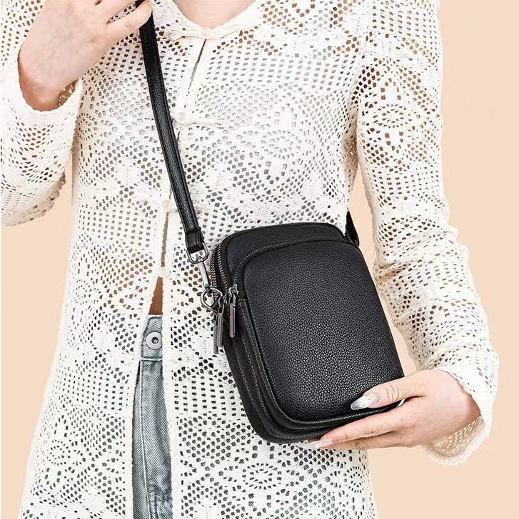 Lifestyle image of woman wearing a white crocheted top with the black Alina's Double Compartment with Front Pocket RFID Crossbody