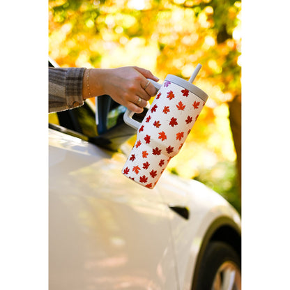 A hand holds a Grosche Aspen 32oz Insulated Tumbler, extended from a white car window.
