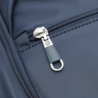 Close-up of a gray zipper with "B" pull on the Beside-U Aileen R1 Backpack, water-repellent nylon.