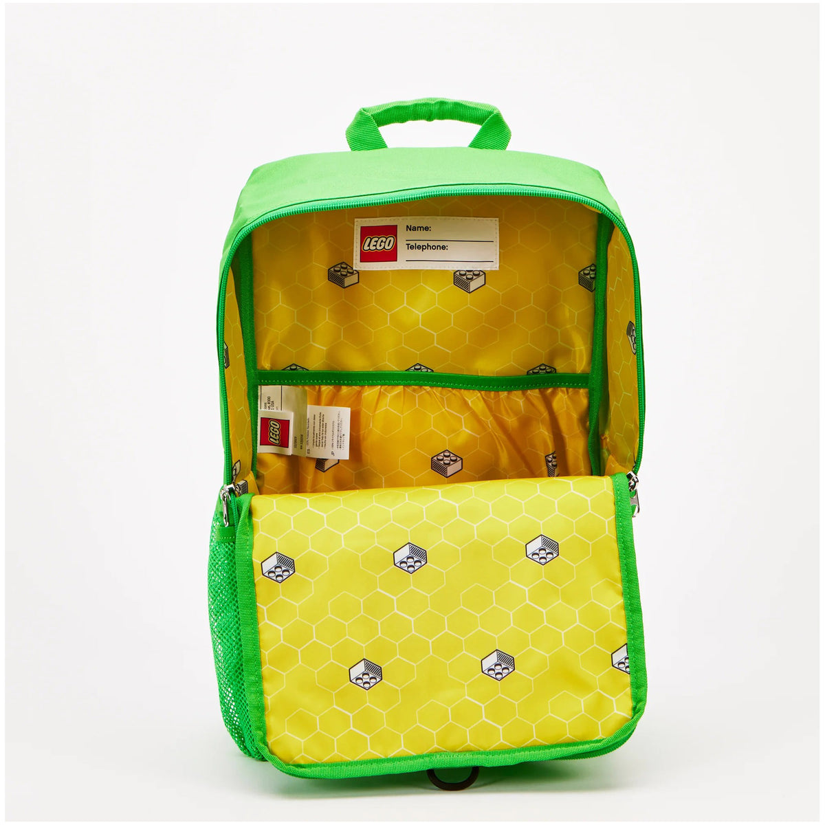 Open green LEGO® Brick Backpack with a yellow interior, white hexagon and brick pattern, and a name tag.