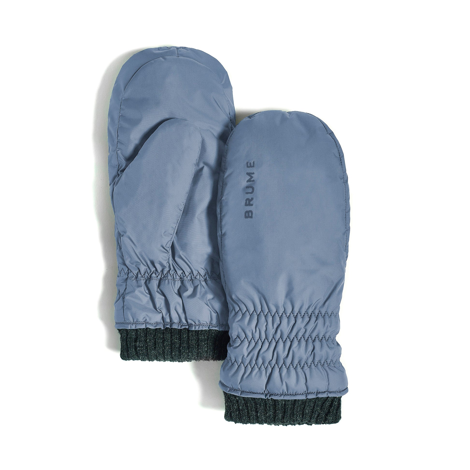 A pair of Brume Magog Mitts in light blue, wind and water resistant with ribbed dark cuffs and "BRUME" print.