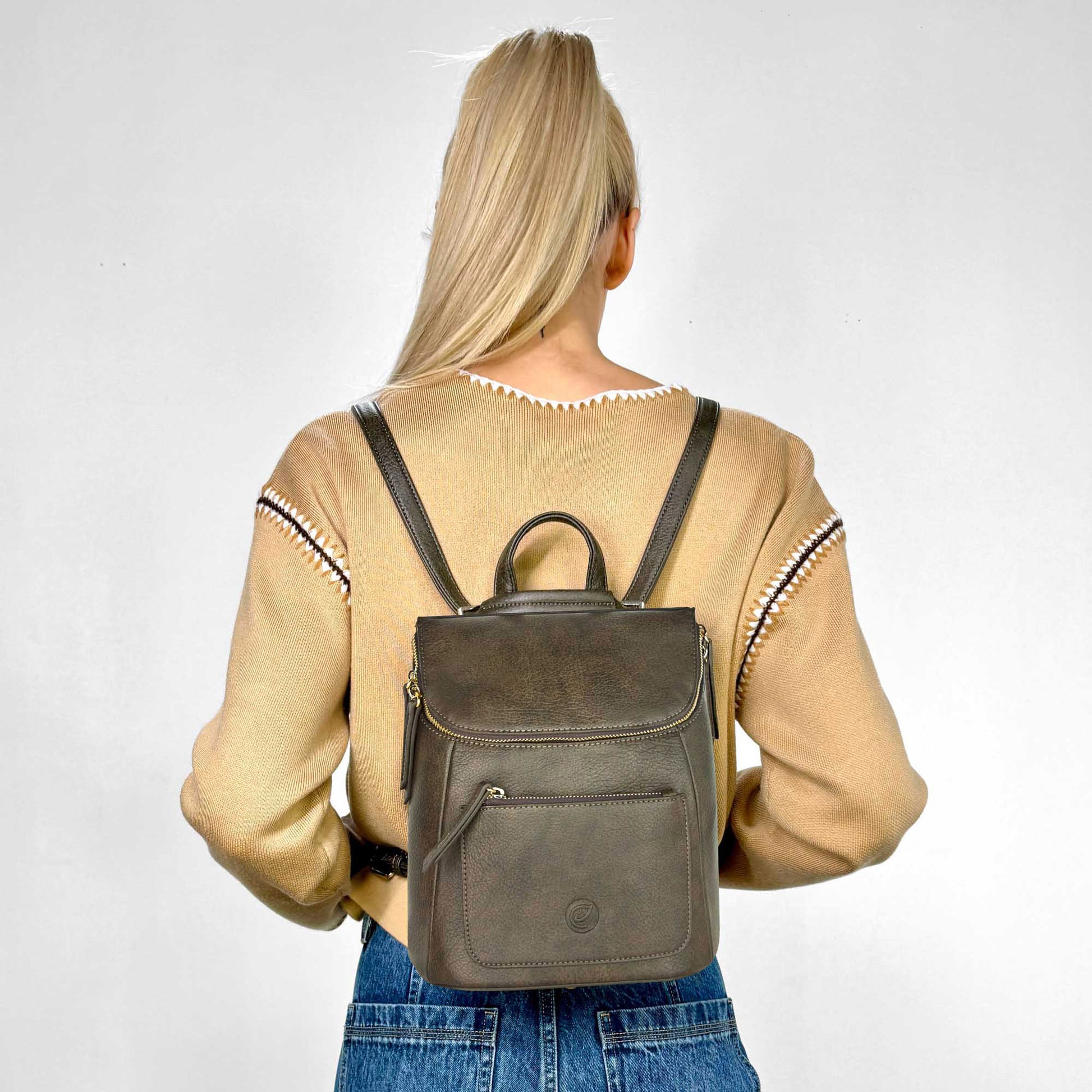 Back view of a woman wearing a yellow sweater and the Espe Bella Backpack in moss green