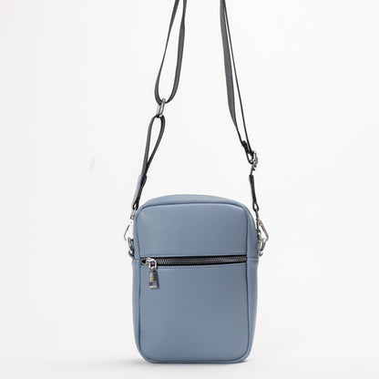 Miss Caprice Compact Crossbody: a light blue rectangular bag with front zipper, ideal for daily use and travel.